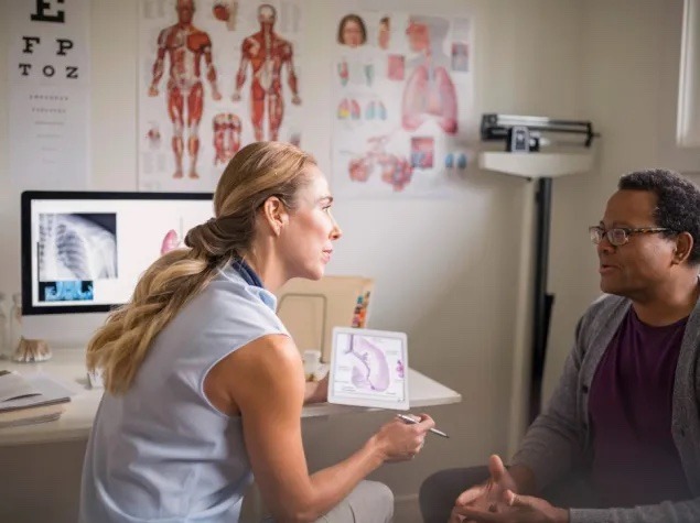 A doctor is talking with a patient in an office.